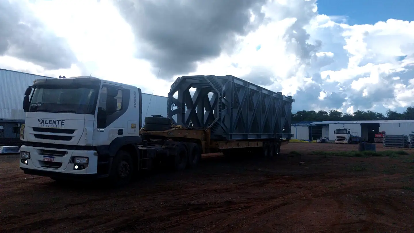 Grande estrutura metálica transportada em carreta industrial