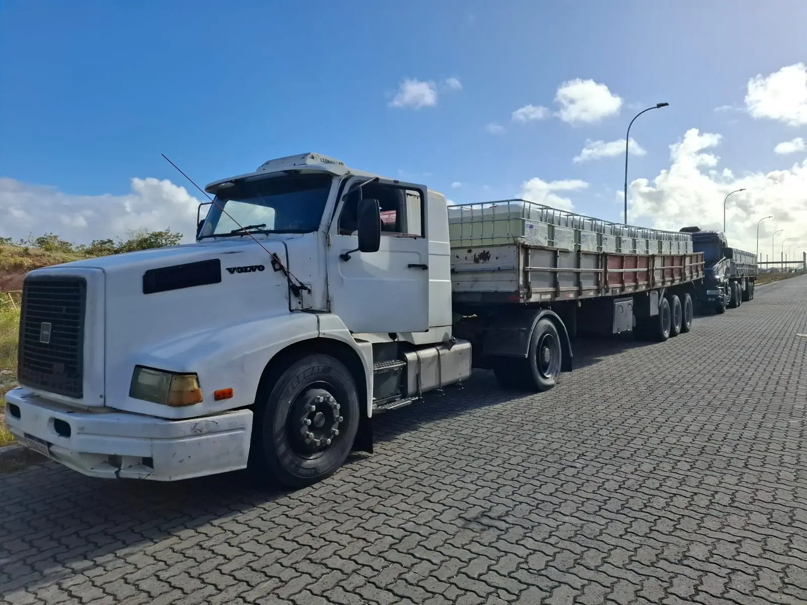 Caminhão de carga em operação rodoviária com outro veículo ao fundo